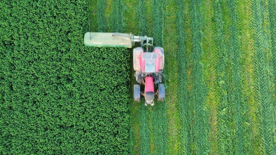 Tractor driving straight lines across a green field using GPS guidance